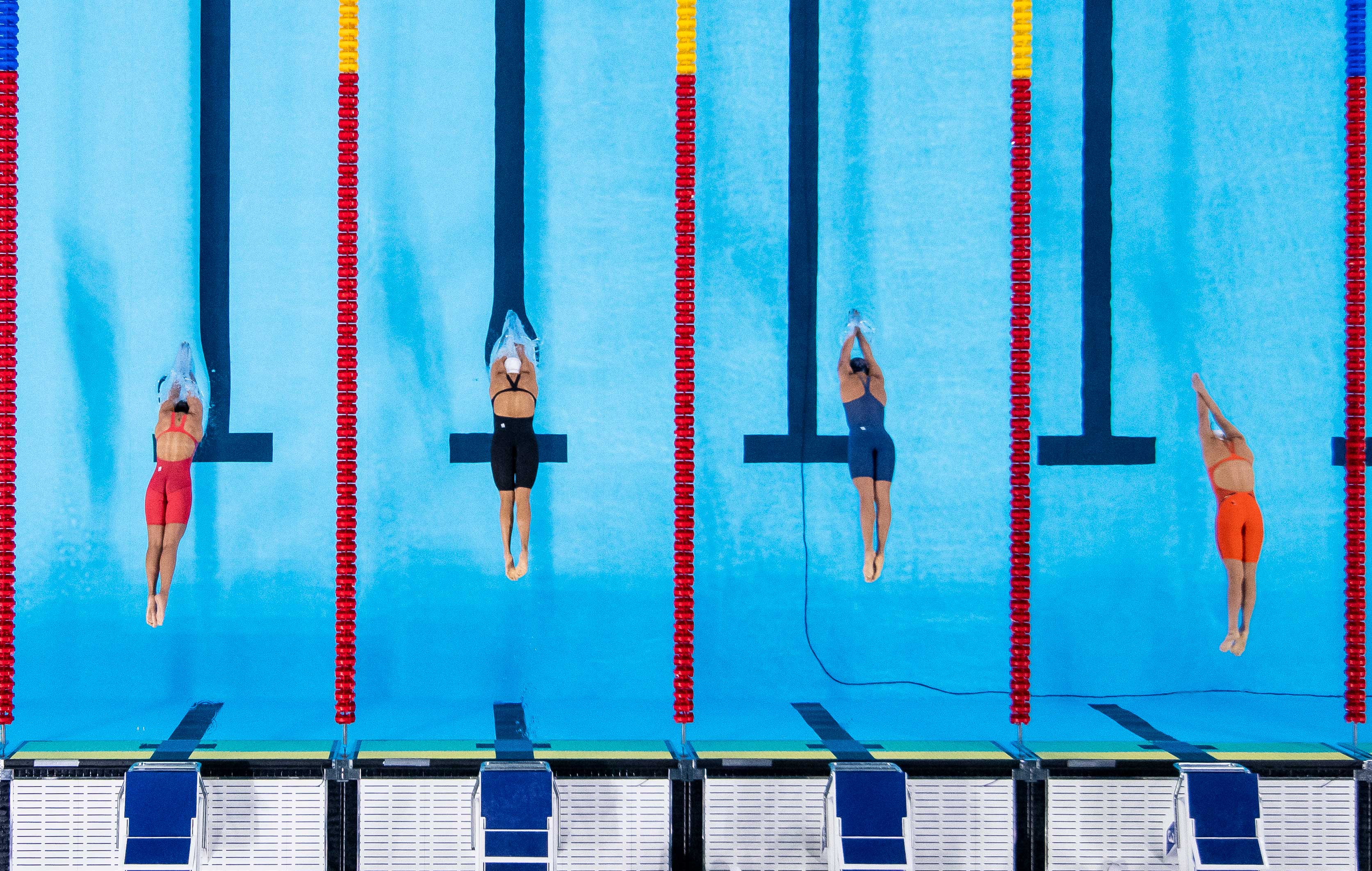 4 swinning athletes are jumping in the pool (top view)